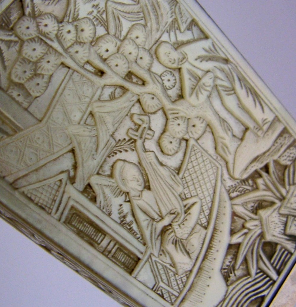 A small tapered antique Chinese export silver etui featuring intricately carved cream-coloured relief panels depicting figures in a garden setting. View II