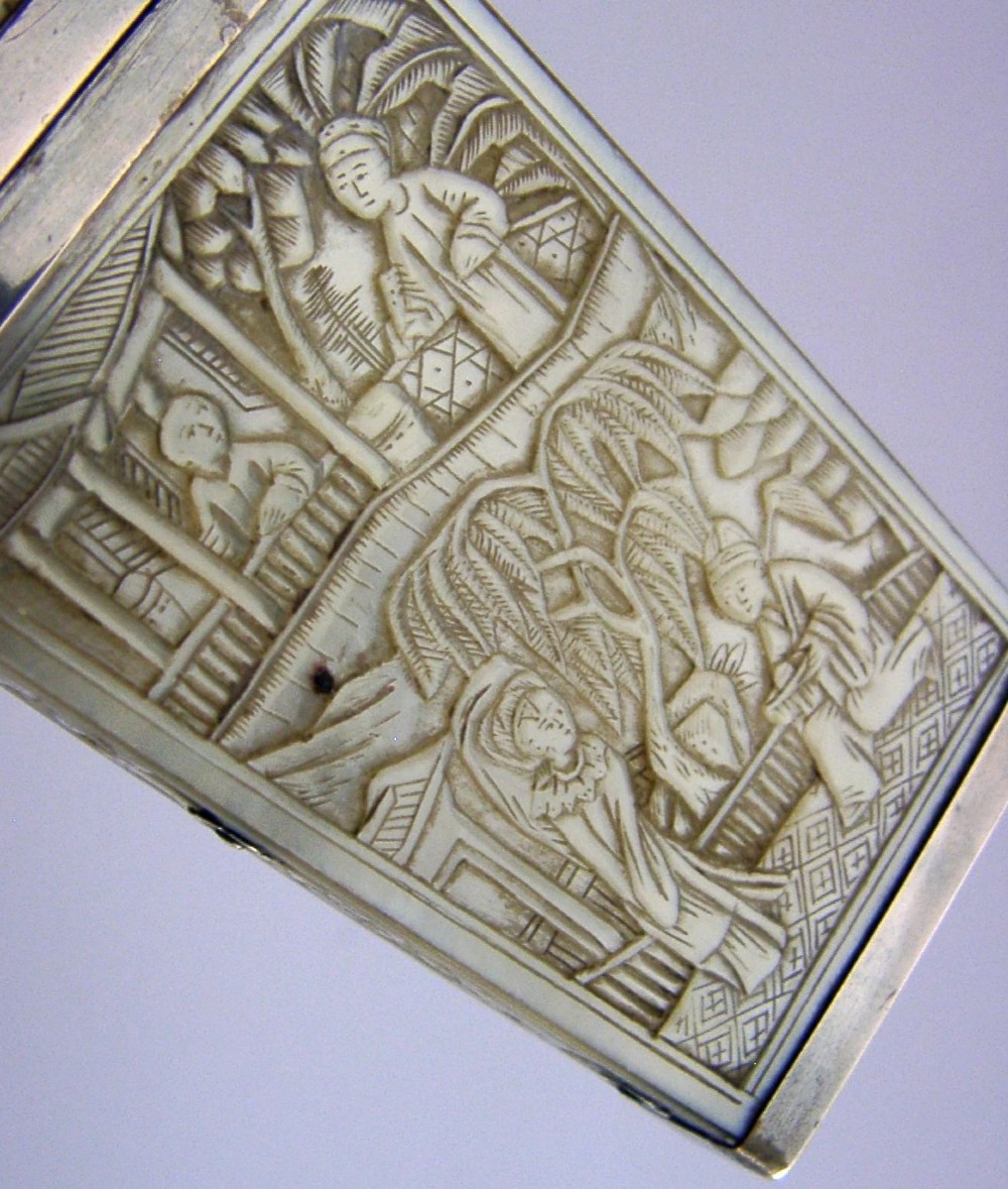 A small tapered antique Chinese export silver etui featuring intricately carved cream-coloured relief panels depicting figures in a garden setting. View V