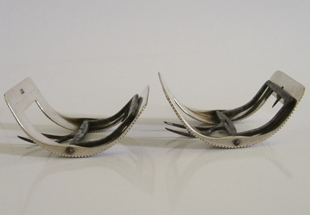 A pair of curved Georgian sterling silver shoe buckles featuring beaded borders and steel mechanism prongs. View VII