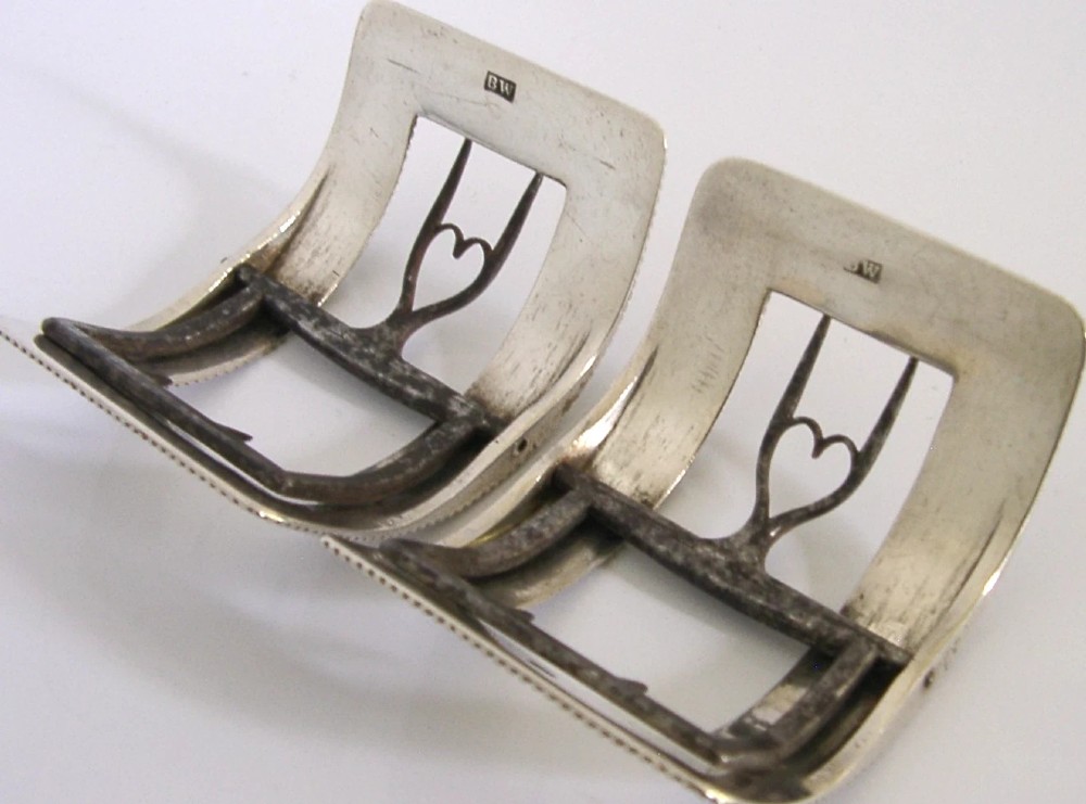 A pair of curved Georgian sterling silver shoe buckles featuring beaded borders and steel mechanism prongs. View VIII