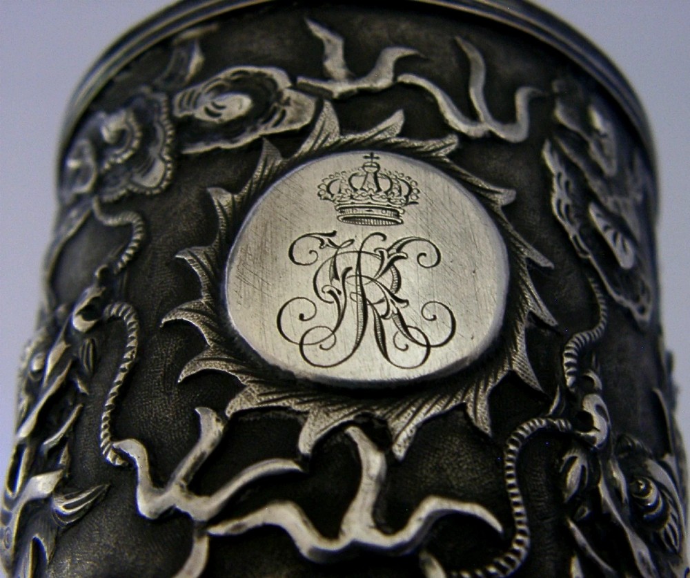 A cylindrical Chinese export silver beaker featuring high-relief repousse dragon motifs and an oval cartouche engraved with a royal monogram beneath a crown. View VIII