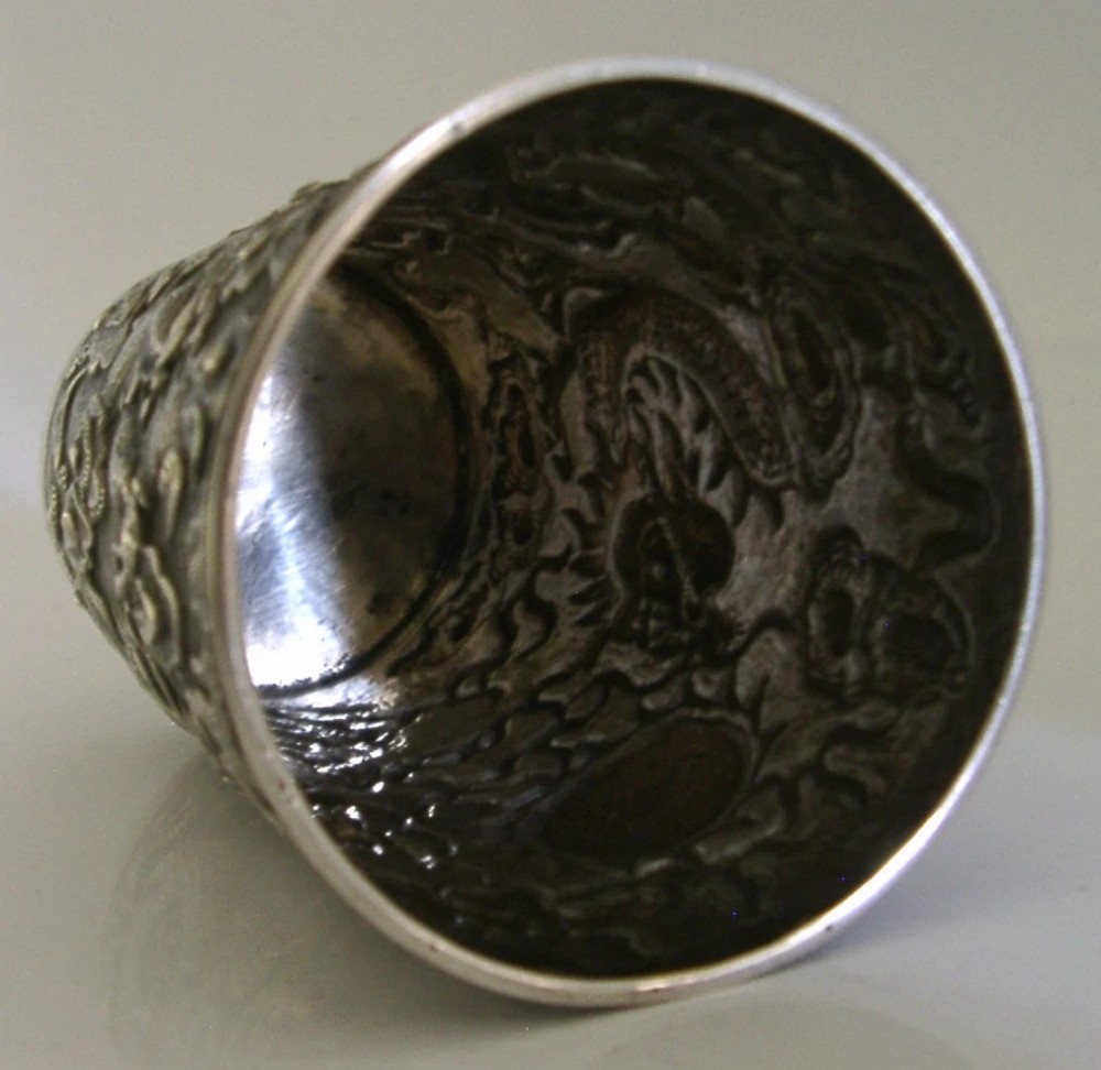 A cylindrical Chinese export silver beaker featuring high-relief repousse dragon motifs and an oval cartouche engraved with a royal monogram beneath a crown. View IX