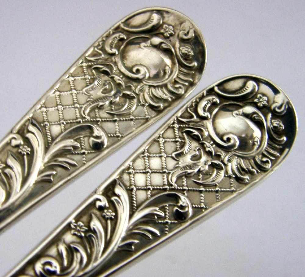 A pair of Victorian sterling silver serving spoons with scalloped shell bowls in a fitted red satin and black velvet presentation case. View III