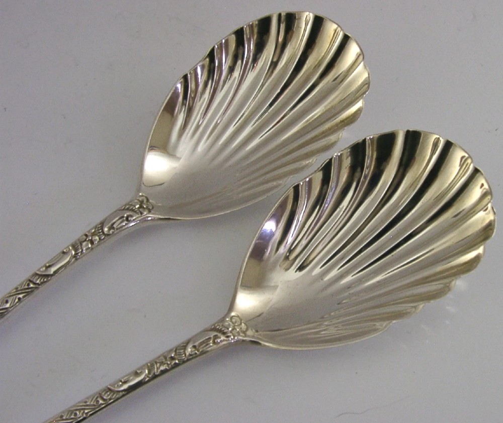A pair of Victorian sterling silver serving spoons with scalloped shell bowls in a fitted red satin and black velvet presentation case. View VIII