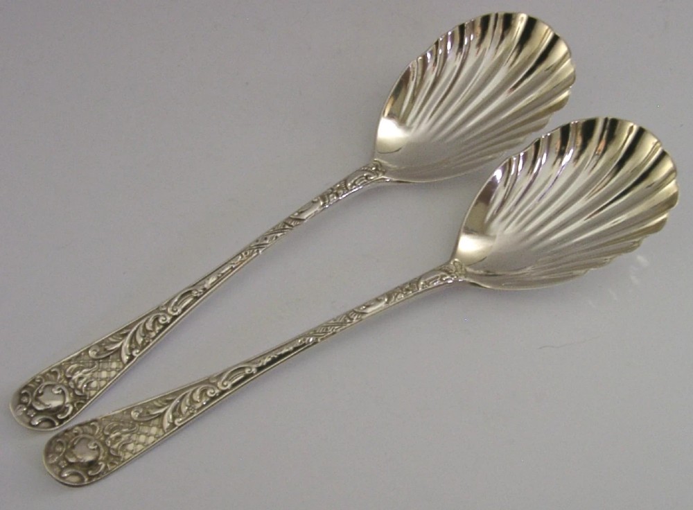 A pair of Victorian sterling silver serving spoons with scalloped shell bowls in a fitted red satin and black velvet presentation case. View IX