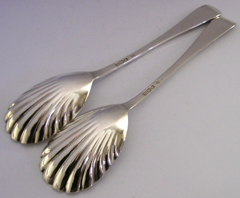 A pair of Victorian sterling silver serving spoons with scalloped shell bowls in a fitted red satin and black velvet presentation case. View X