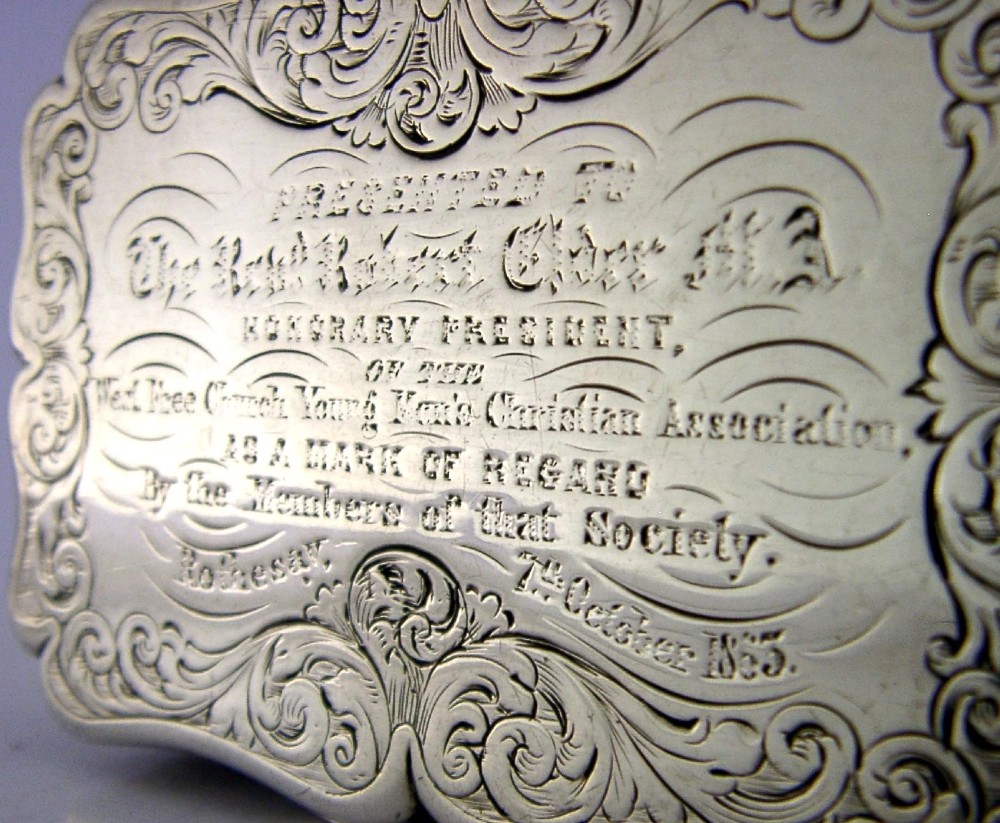 An engraved Victorian sterling silver snuff box with shaped edges, scrollwork border, and engraved inscription on the lid. View II