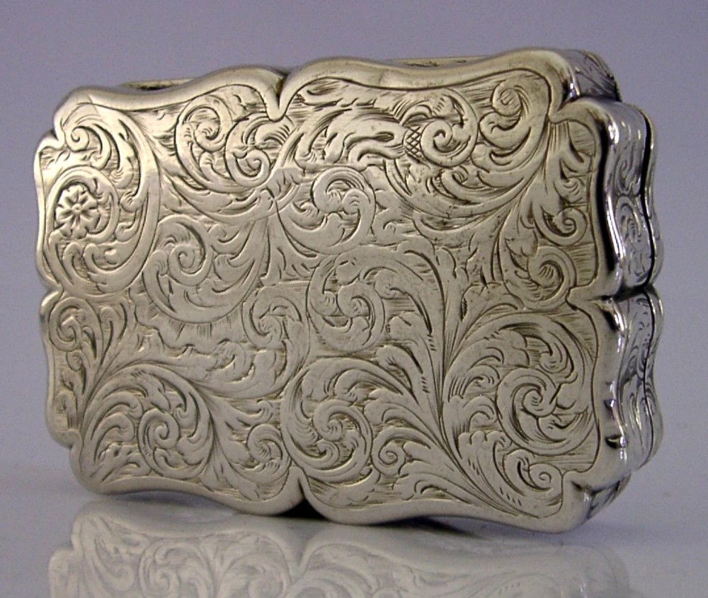 An engraved Victorian sterling silver snuff box with shaped edges, scrollwork border, and engraved inscription on the lid. View IV