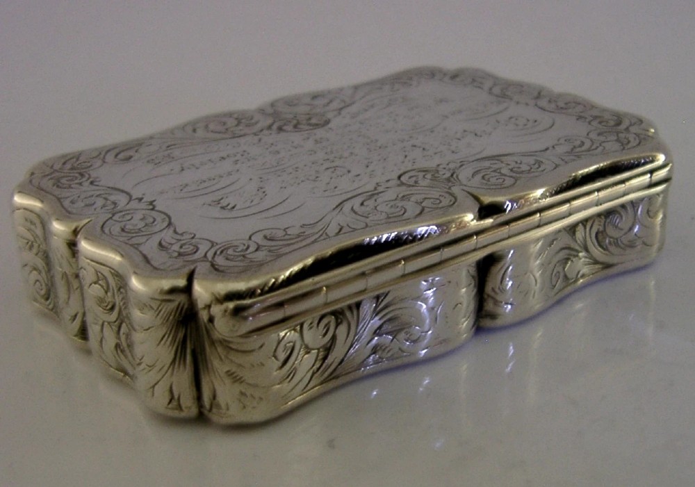 An engraved Victorian sterling silver snuff box with shaped edges, scrollwork border, and engraved inscription on the lid. View VII