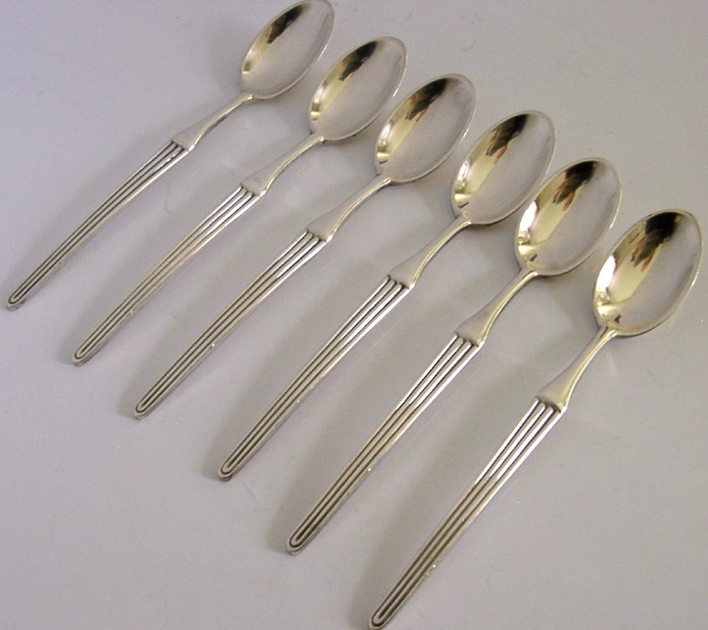 A set of six mid-century solid silver spoons featuring slim handles with reeded linear decoration and oval bowls. View III
