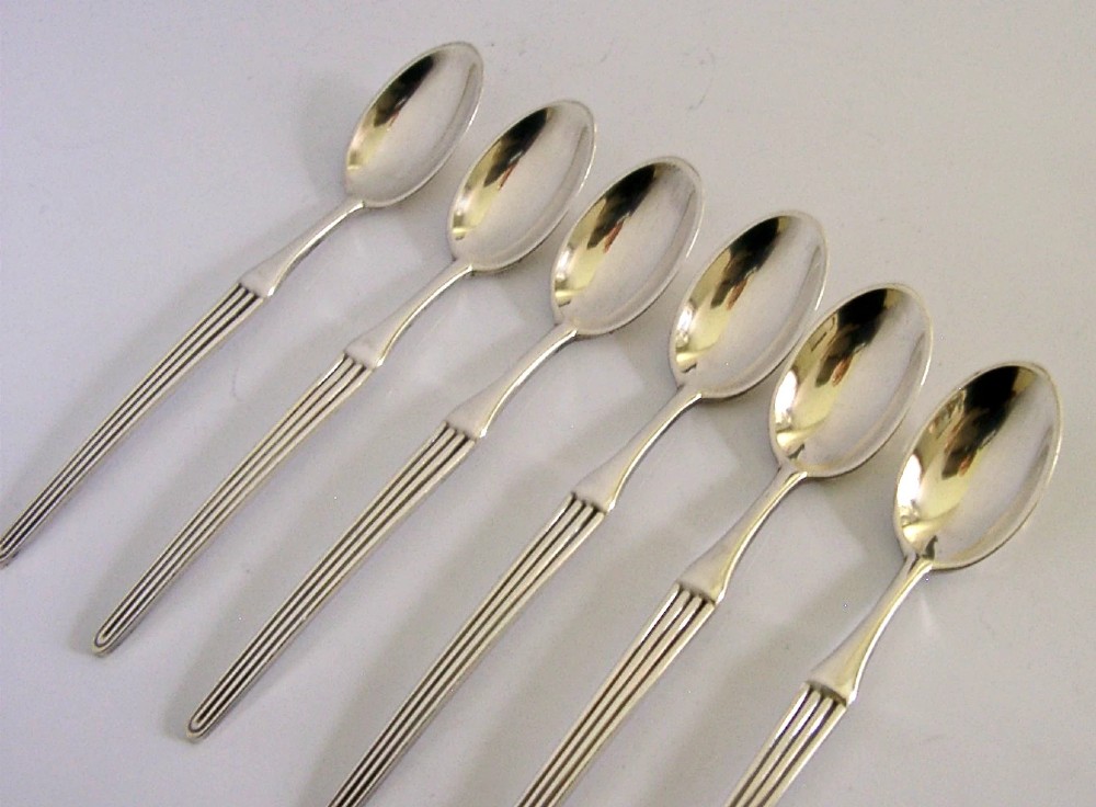 A set of six mid-century solid silver spoons featuring slim handles with reeded linear decoration and oval bowls. View IV