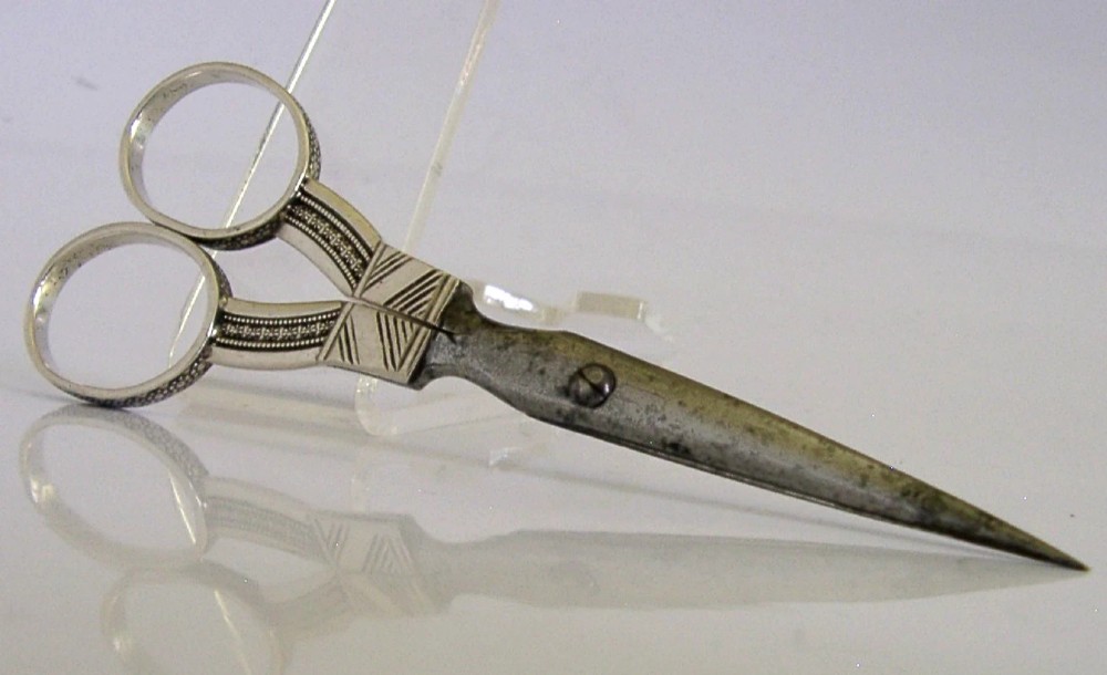 A pair of 19th-century Dutch solid silver needlework scissors featuring engraved oval finger loops and steel blades. View IV