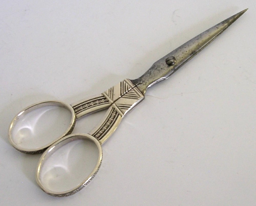 A pair of 19th-century Dutch solid silver needlework scissors featuring engraved oval finger loops and steel blades. View VI