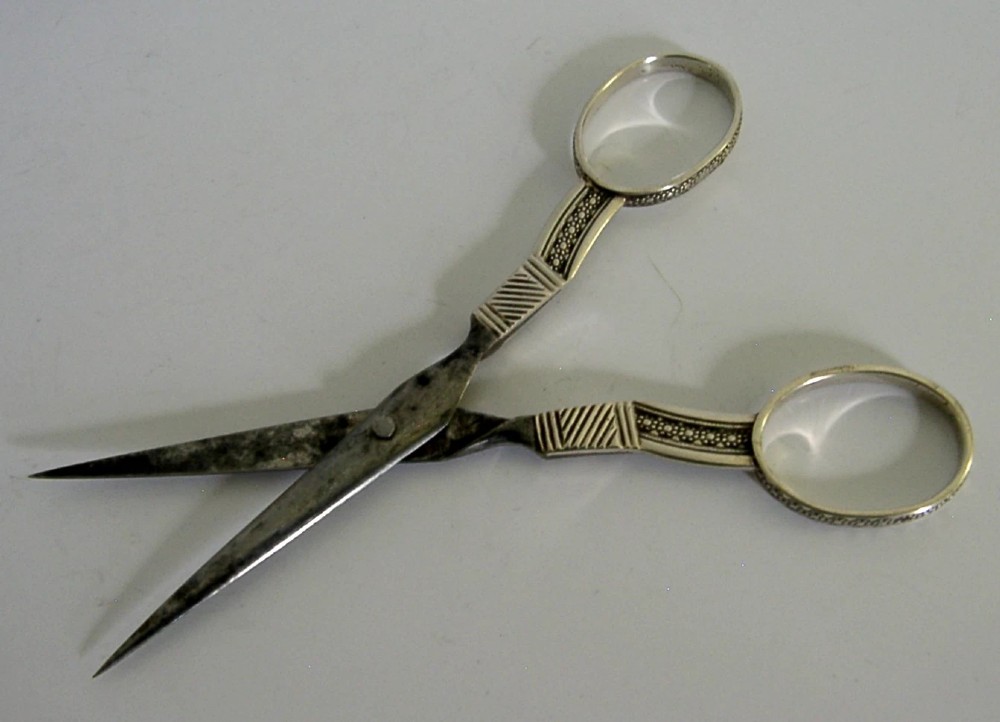 A pair of 19th-century Dutch solid silver needlework scissors featuring engraved oval finger loops and steel blades. View VII