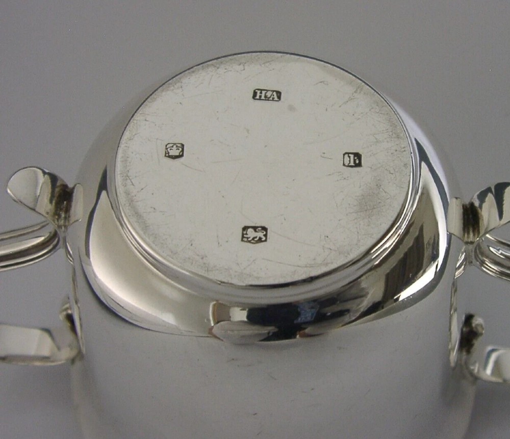 A polished sterling silver porringer bowl featuring a flared rim, rounded body, and twin loop side handles. View VI