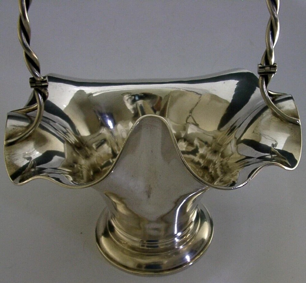 An antique solid silver Art Nouveau basket bowl with a fluted, lobed rim and an overhead twisted wire swing handle. View IV
