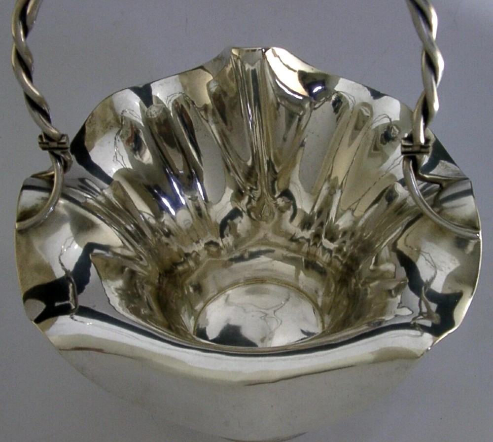 An antique solid silver Art Nouveau basket bowl with a fluted, lobed rim and an overhead twisted wire swing handle. View VI