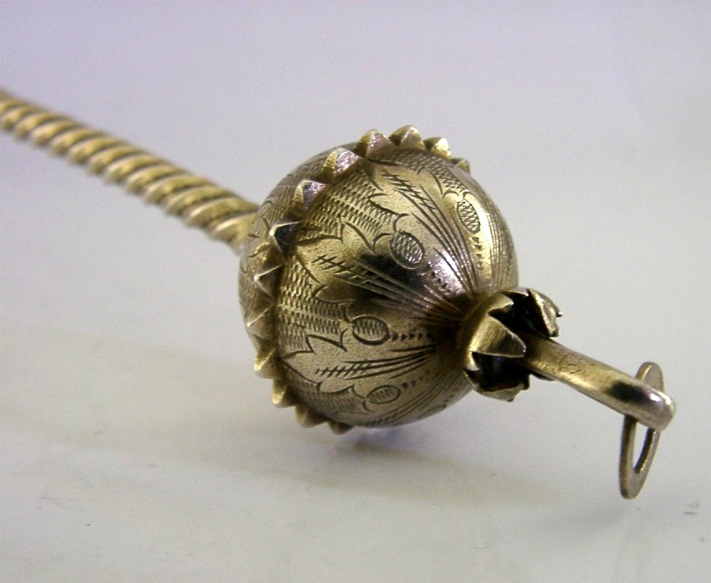 An antique Danish solid silver gilt serving spoon featuring an engraved circular bowl, a twisted stem, and a decorative finial. View III