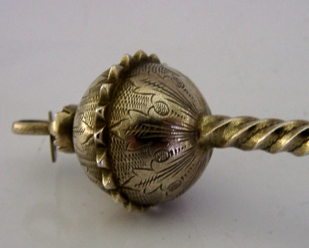 An antique Danish solid silver gilt serving spoon featuring an engraved circular bowl, a twisted stem, and a decorative finial. View VI