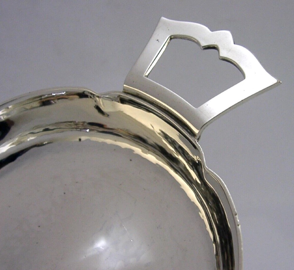 A planished sterling silver quaich featuring a lobed shallow bowl and two flat geometric handles. View II