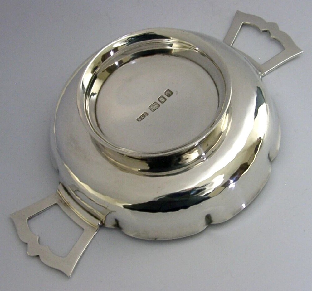 A planished sterling silver quaich featuring a lobed shallow bowl and two flat geometric handles. View III