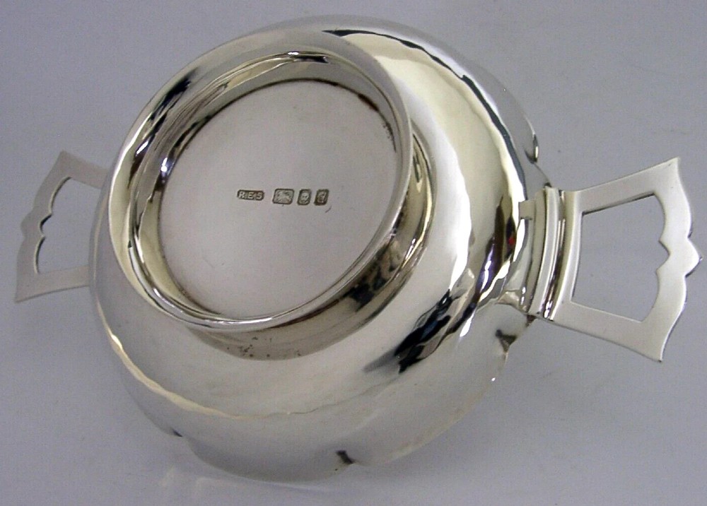 A planished sterling silver quaich featuring a lobed shallow bowl and two flat geometric handles. View V