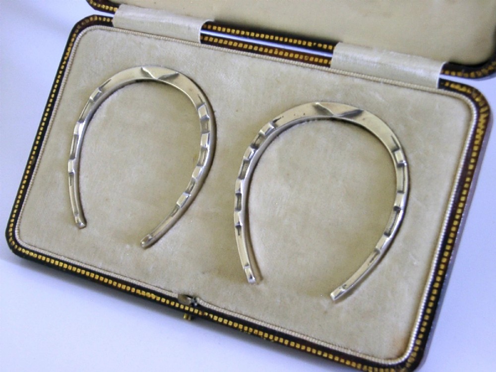 A pair of sterling silver horseshoe-shaped napkin rings presented inside a silk-lined leatherette presentation box. View III