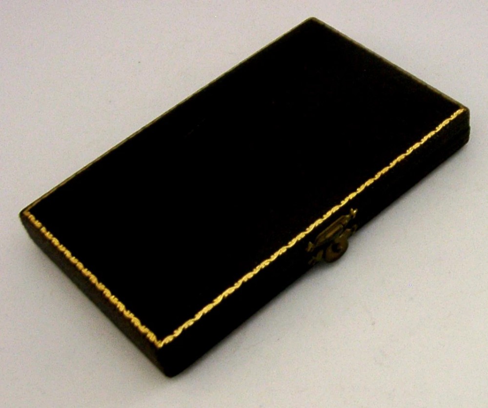 A set of two sterling silver horseshoe-shaped napkin rings presented inside a fitted black presentation case. View VI