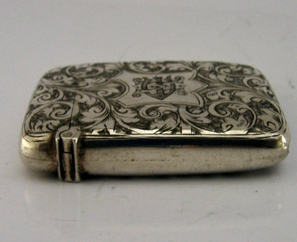 Victorian sterling silver vesta case decorated with hand-engraved foliate scrollwork and a central monogrammed shield cartouche. View V