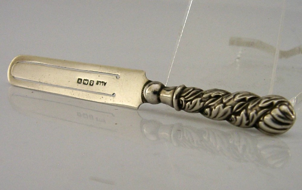 An antique sterling silver page marker featuring a flat clipped body with clear hallmarks and a decorative spiralled handle.