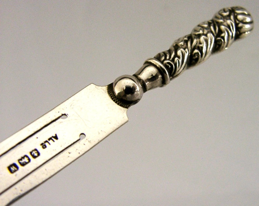 An antique sterling silver page marker featuring a flat clipped body with clear hallmarks and a decorative spiralled handle. View II
