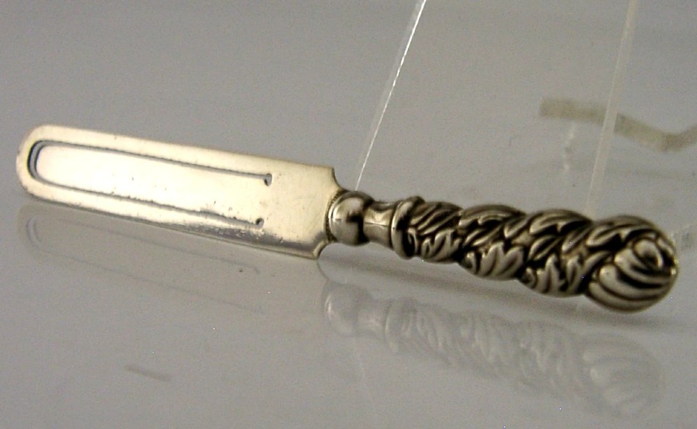 An antique sterling silver page marker featuring a flat clipped body with clear hallmarks and a decorative spiralled handle. View IV