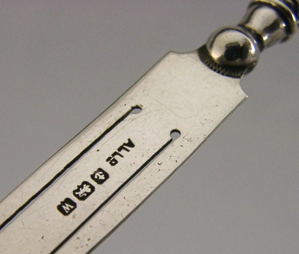 An antique sterling silver page marker featuring a flat clipped body with clear hallmarks and a decorative spiralled handle. View V