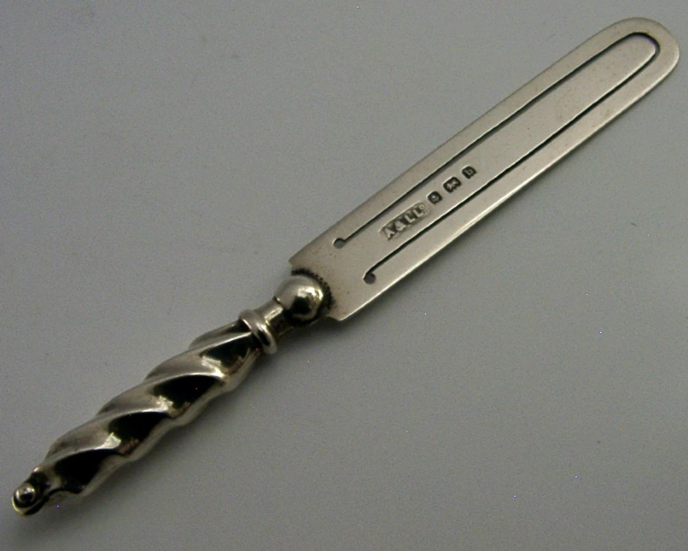 An antique sterling silver bookmark with a spiral twist handle and a flat page clip bearing English hallmarks.