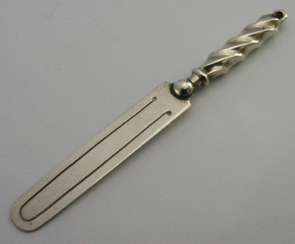 An antique sterling silver bookmark with a spiral twist handle and a flat page clip bearing English hallmarks. View IV