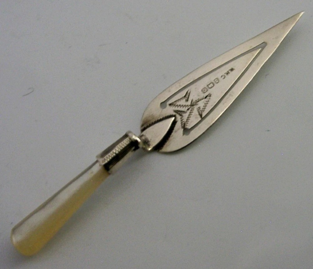 An Edwardian sterling silver bookmark with a tapered mother of pearl handle and an engraved silver clip bearing the Isle of Man triskelion emblem.
