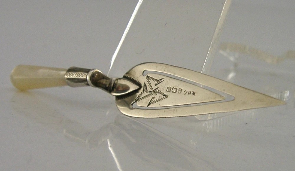 An Edwardian sterling silver bookmark with a tapered mother of pearl handle and an engraved silver clip bearing the Isle of Man triskelion emblem. View IV