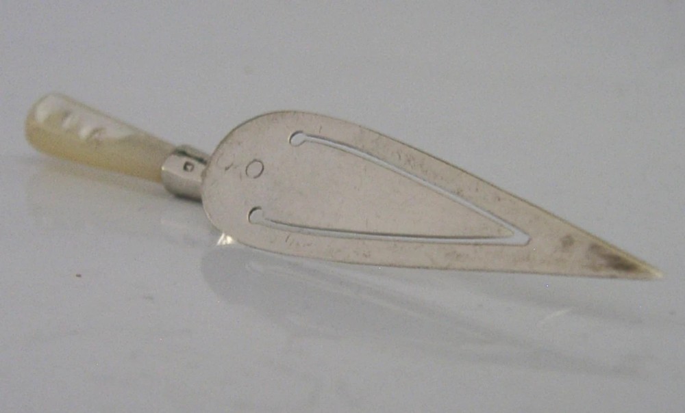 An Edwardian sterling silver bookmark with a tapered mother of pearl handle and an engraved silver clip bearing the Isle of Man triskelion emblem. View V