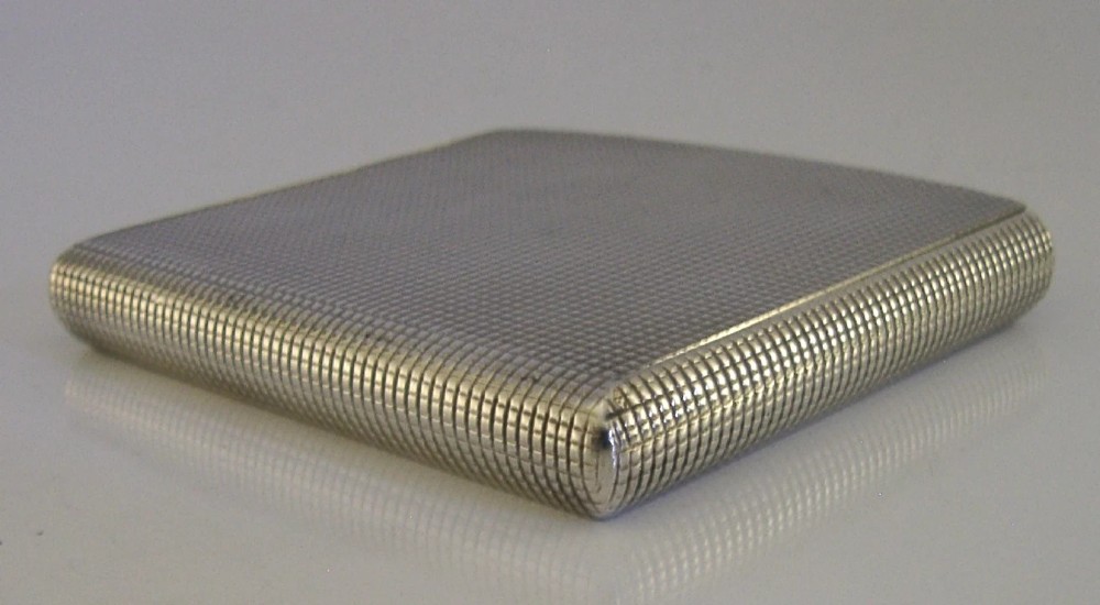 An open sterling silver case displaying an engine-turned grid pattern on the exterior and a gilt metallic interior. View VII