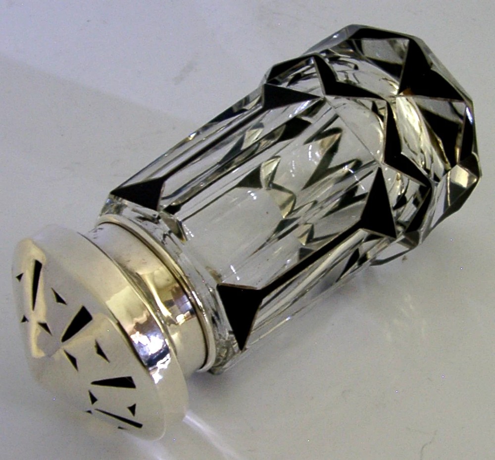 An Art Deco sugar caster featuring a faceted cut-glass body with black geometric enamel details and a pierced sterling silver top. View II
