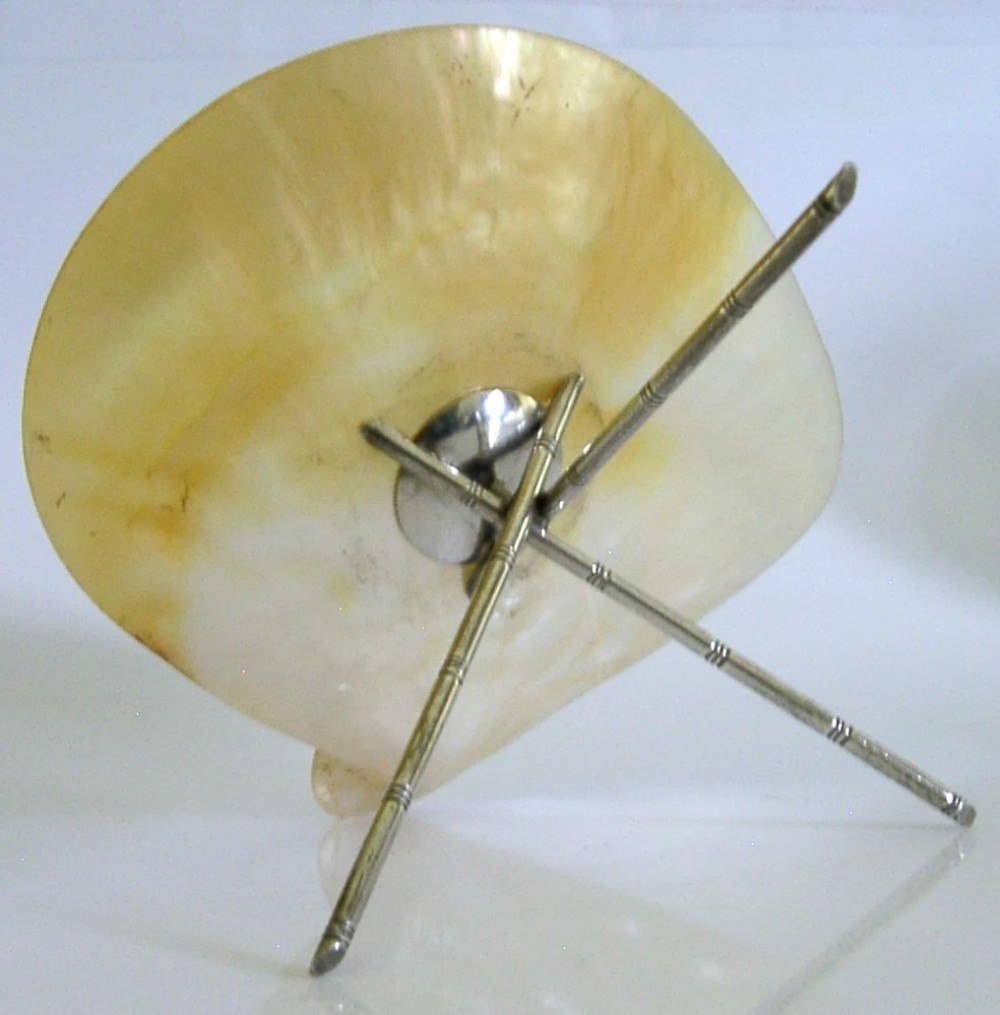 An antique mother-of-pearl shell dish supported on three slender silver tripod legs with a small central silver stud. View VI