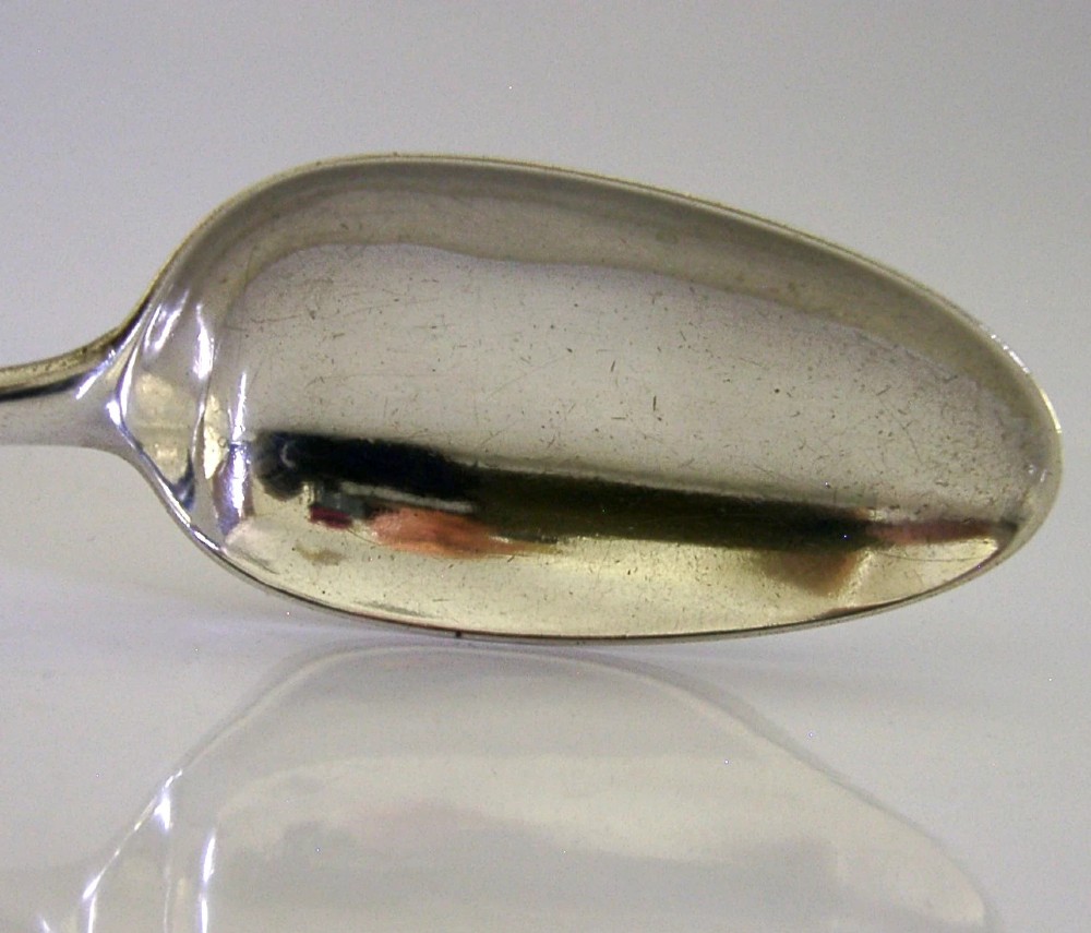 An 18th-century Georgian sterling silver basting spoon featuring a long, tapered stem and a polished oval bowl. View IV