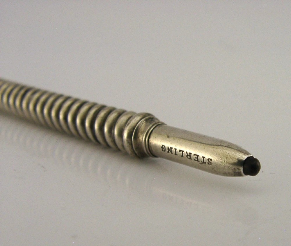 A Victorian sterling silver propelling pencil featuring a ribbed barrel design and a rounded fluted finial. View II