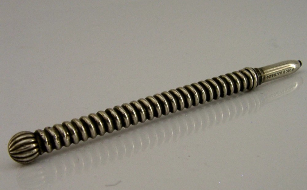 A Victorian sterling silver propelling pencil featuring a ribbed barrel design and a rounded fluted finial. View IV