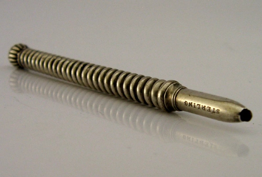 A Victorian sterling silver propelling pencil featuring a ribbed barrel design and a rounded fluted finial. View VI