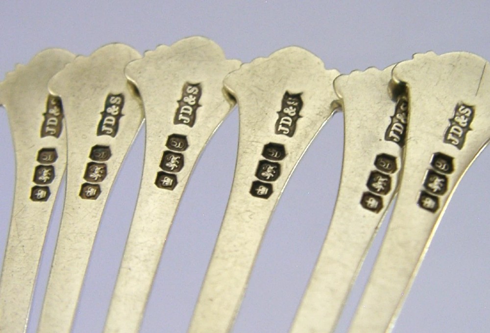 A set of six sterling silver teaspoons featuring twisted stems and shell motif terminals displayed on a light surface. View VI