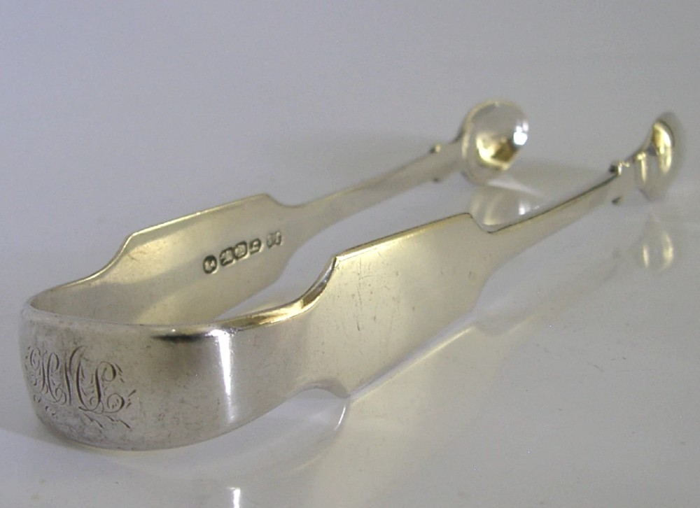 A pair of Victorian sterling silver sugar tongs featuring a classic Fiddle pattern handle and spoon-shaped grips. View II