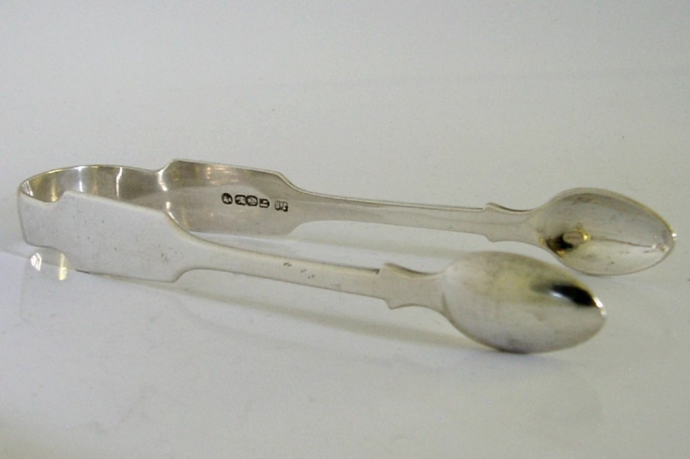 A pair of Victorian sterling silver sugar tongs featuring a classic Fiddle pattern handle and spoon-shaped grips. View III