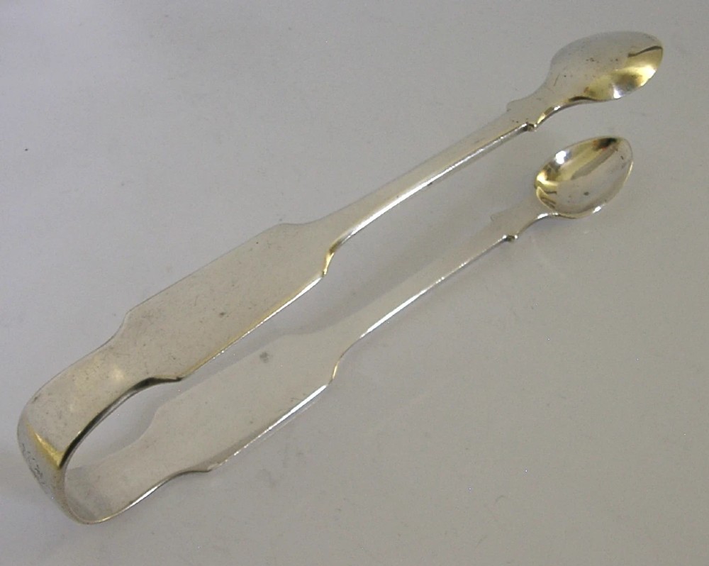 A pair of Victorian sterling silver sugar tongs featuring a classic Fiddle pattern handle and spoon-shaped grips. View V