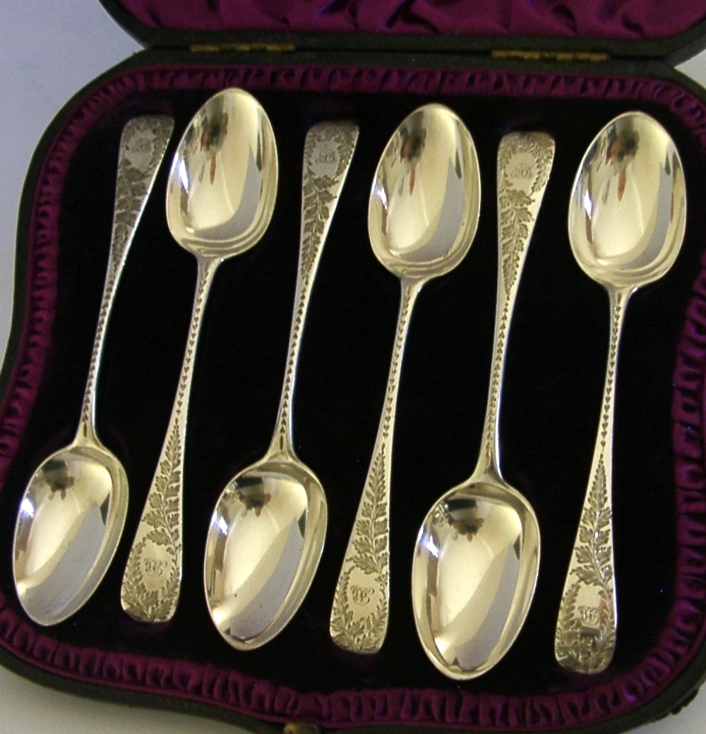A set of six engraved Victorian sterling silver spoons arranged inside a black fitted presentation case lined with deep purple velvet. View VIII